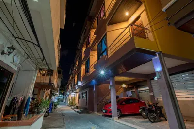 a red car parked outside of a building at night at Amarin Hotel Patong in Patong Beach
