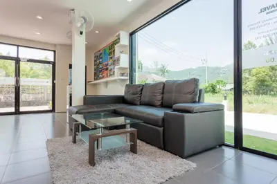a living room with a leather couch and a table at Journey Residence Phuket in Bang Tao Beach