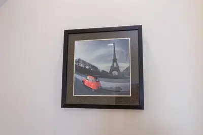 a picture of the eiffel tower and a red car on a wall at Journey Residence Phuket in Bang Tao Beach