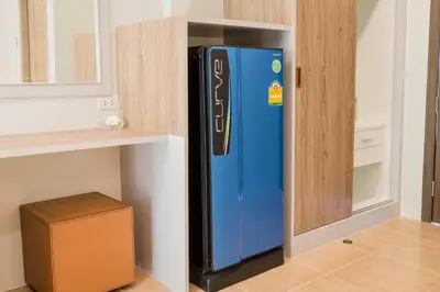 a blue refrigerator in a kitchen next to a shelf at Journey Residence Phuket in Bang Tao Beach