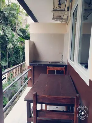 a table and chairs on a balcony with a sink at Smile Home in Patong Beach