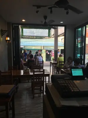 a group of people sitting at tables in a restaurant at Smile Home in Patong Beach