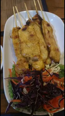 a plate of food with chopsticks and a salad at Smile Home in Patong Beach