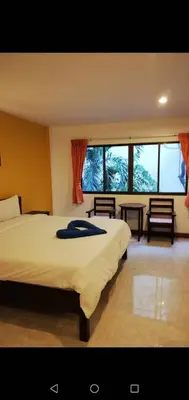 a bedroom with a large bed and a large window at Smile Home in Patong Beach