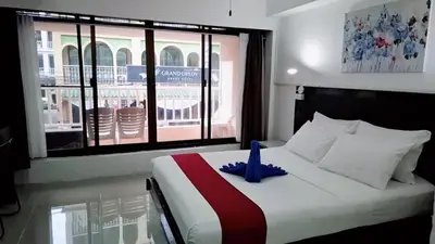 a bedroom with a bed with a blue ribbon on it at Boomerang Inn in Patong Beach