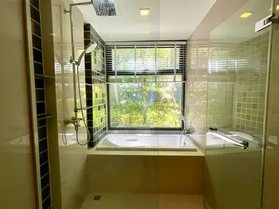 a bathroom with a shower and a sink and a window at The Deck Patong by VIP in Patong Beach