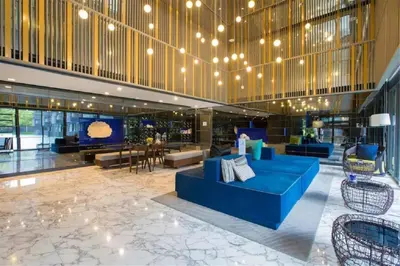 a lobby with a blue couch in a building at The Deck Patong by VIP in Patong Beach