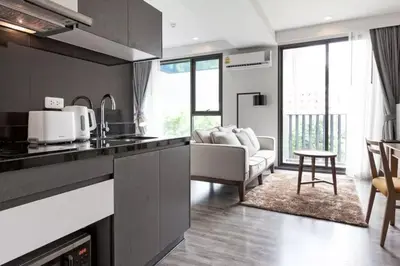 a kitchen and living room with a couch and a table at The Deck Patong by VIP in Patong Beach