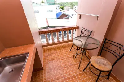 a small balcony with a sink and a table and chairs at Mala Hotel in Kata Beach