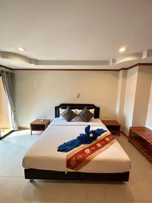 a bedroom with a bed with a blue blanket on it at Mala Hotel in Kata Beach
