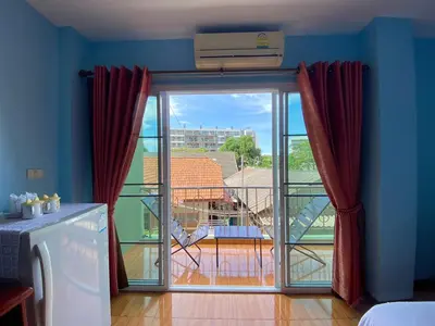 a room with a sliding glass door with a balcony at Mala Hotel in Kata Beach