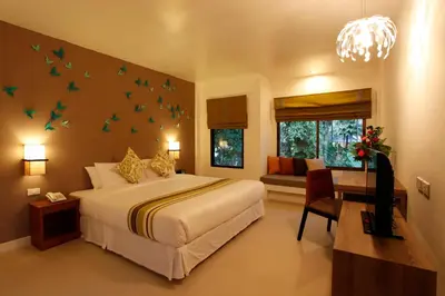 a bedroom with a large bed with birds on the wall at The Viridian Resort Patong in Patong Beach