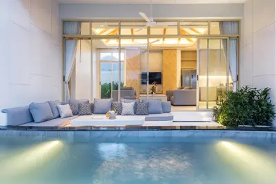 a living room with a couch and a swimming pool at Himmapana Villas - SHA Extra Plus in Kamala Beach