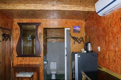a kitchen with a refrigerator and a door to a room at Ruan Mai Naiyang Beach Resort in Nai Yang Beach