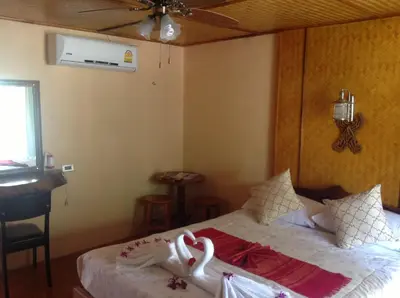 a bedroom with a bed with swans on it at Ruan Mai Naiyang Beach Resort in Nai Yang Beach