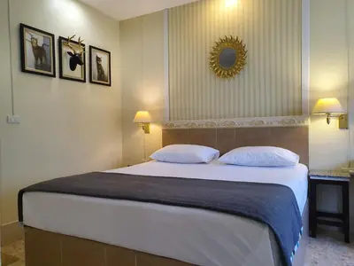 a bedroom with a large white bed with two pillows at Holiday Village And Natural Garden Resort in Karon Beach