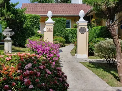 a walkway in front of a house with flowers at Holiday Village And Natural Garden Resort in Karon Beach