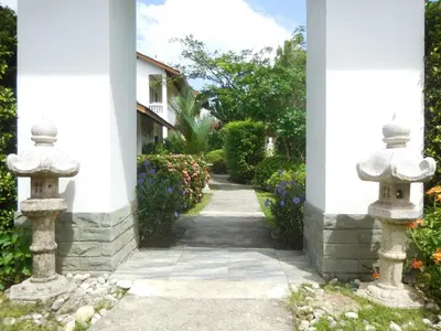 an archway with two stone statues in a garden at Holiday Village And Natural Garden Resort in Karon Beach
