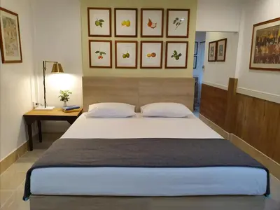 a bedroom with a large bed and a desk at Holiday Village And Natural Garden Resort in Karon Beach