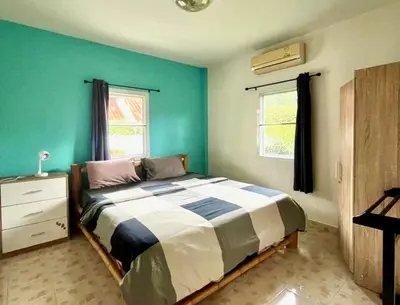 a bedroom with a bed and a green wall at 2 bedroom bungalow Nai Harn 4 Resort in Ban Suan