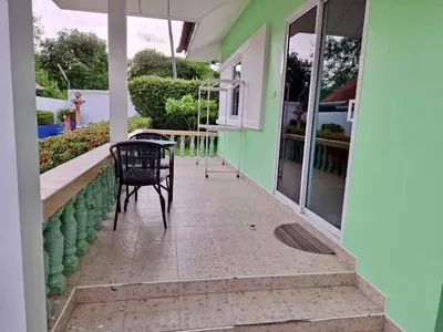 a table and chair on a porch of a house at 2 bedroom bungalow Nai Harn 4 Resort in Ban Suan