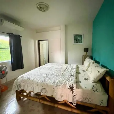 a bedroom with a bed with a white comforter at 2 bedroom bungalow Nai Harn 4 Resort in Ban Suan