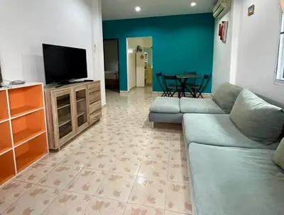 a living room with a couch and a flat screen tv at 2 bedroom bungalow Nai Harn 4 Resort in Ban Suan