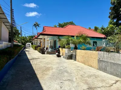 a house with a red roof on a street at 2 bedroom bungalow Nai Harn 4 Resort in Ban Suan