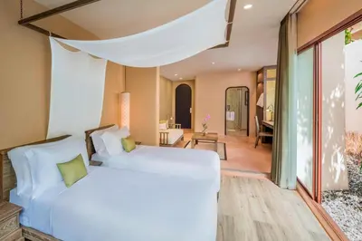 a bedroom with two beds and a living room at The Naka Island, a Luxury Collection Resort & Spa, Phuket in Ko Naka