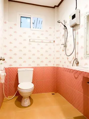 a bathroom with a toilet and a shower at Ban Tidlay - SHA in Ko Yao Noi