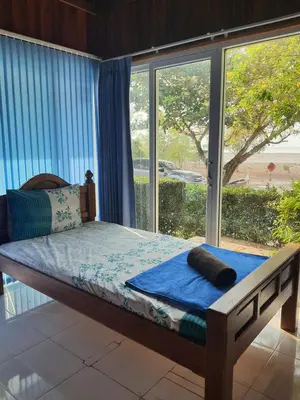 a bed in a room with a large window at Ban Tidlay - SHA in Ko Yao Noi