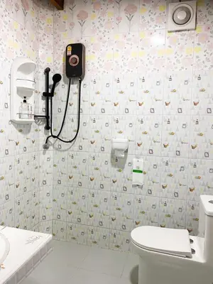 a bathroom with a toilet and a camera on the wall at Ban Tidlay - SHA in Ko Yao Noi