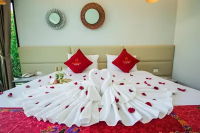 a large white bed with red pillows on it at Good Night Pool Villa Phuket - SHA Plus in Phuket Town