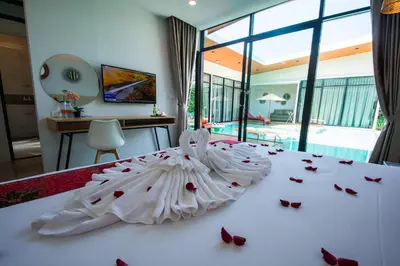 a bedroom with a white bed with roses on it at Good Night Pool Villa Phuket - SHA Plus in Phuket Town