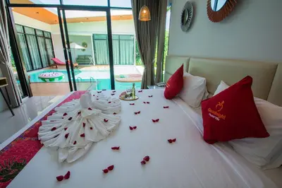 a bed with red and white decorations on it at Good Night Pool Villa Phuket - SHA Plus in Phuket Town