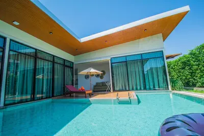 a swimming pool in a house with glass walls at Good Night Pool Villa Phuket - SHA Plus in Phuket Town
