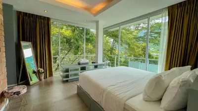 a bedroom with a bed and a large window at Great view in 81sqm top floor space in Kamala in Kamala Beach