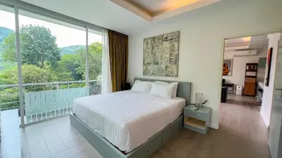 a bedroom with a bed and a large window at Great view in 81sqm top floor space in Kamala in Kamala Beach