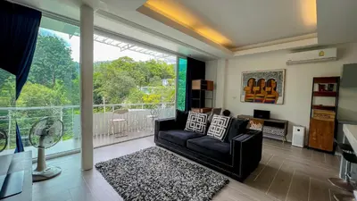 a living room with a couch and a large window at Great view in 81sqm top floor space in Kamala in Kamala Beach