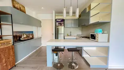 a kitchen with a counter and stools in it at Great view in 81sqm top floor space in Kamala in Kamala Beach