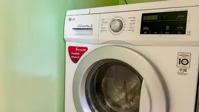 a white washing machine sitting next to a green wall at Great view in 81sqm top floor space in Kamala in Kamala Beach