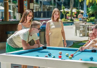 a group of people standing around a pool table at Radisson Resort and Suites Phuket in Kamala Beach