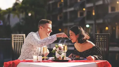 a man and a woman sitting at a table at Radisson Resort and Suites Phuket in Kamala Beach