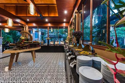 a restaurant with a buffet line with white plates at Princess Kamala Beachfront Hotel - SHA Extra Plus in Kamala Beach