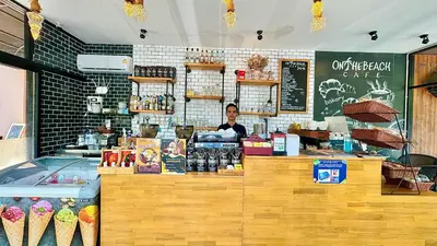 a woman standing behind a counter in a bakery at Princess Kamala Beachfront Hotel - SHA Extra Plus in Kamala Beach