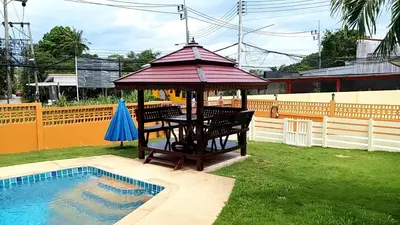 a gazebo with a table next to a pool at Résidence Chez Nous Phuket in Rawai Beach