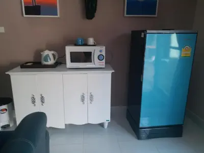 a microwave sitting on a counter next to a refrigerator at Résidence Chez Nous Phuket in Rawai Beach