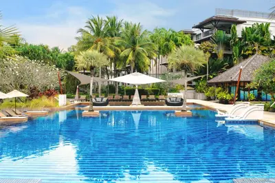a pool at a resort with chairs and umbrellas at Marriott's Mai Khao Resort - Phuket in Mai Khao Beach