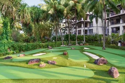 a golf course at the resort with palm trees at Marriott's Mai Khao Resort - Phuket in Mai Khao Beach