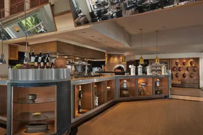 a large kitchen with a bar with wine bottles at Marriott's Phuket Beach Club in Mai Khao Beach